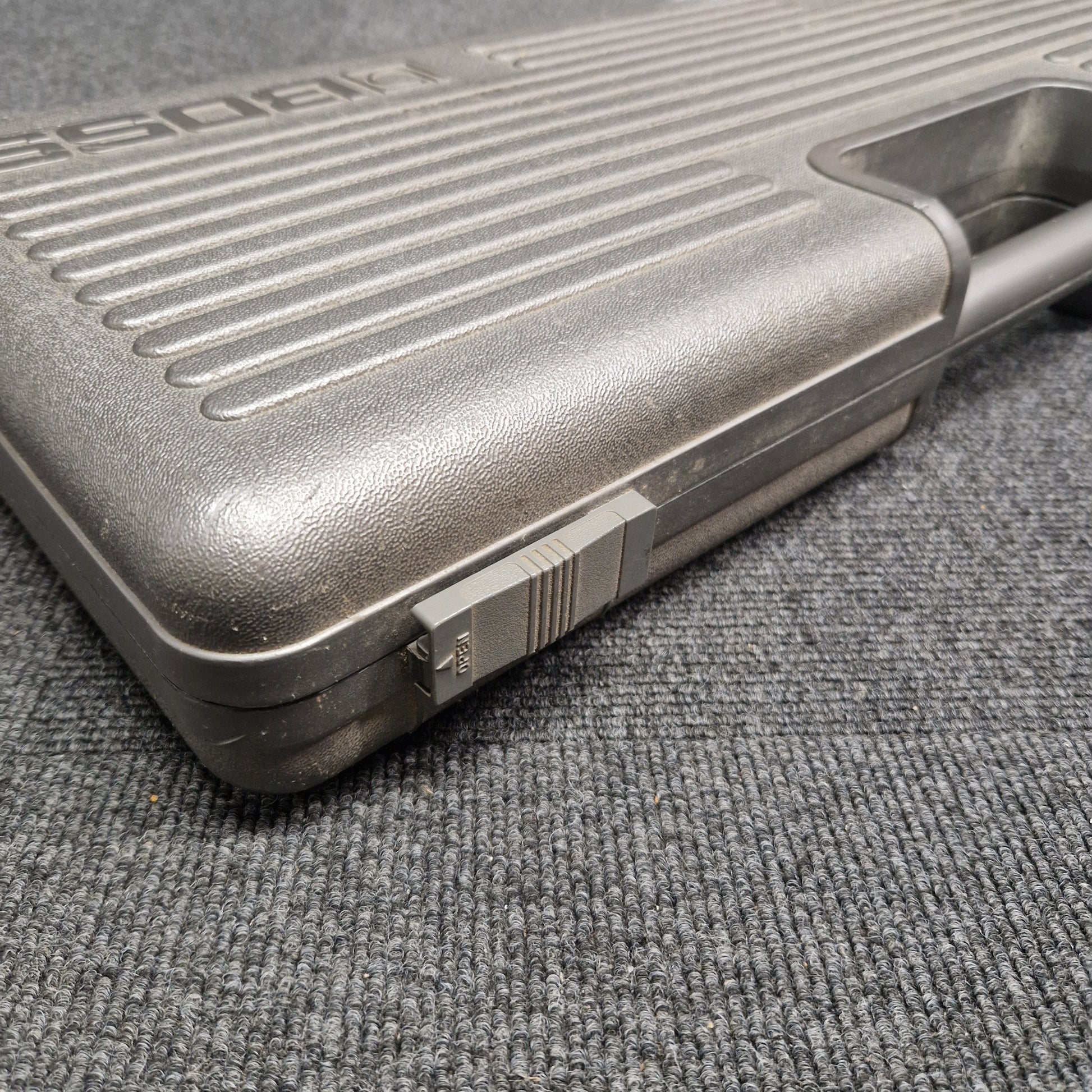 Pre-Owned Boss BCB-6 Close-up of a textured gun grip on a gray surface