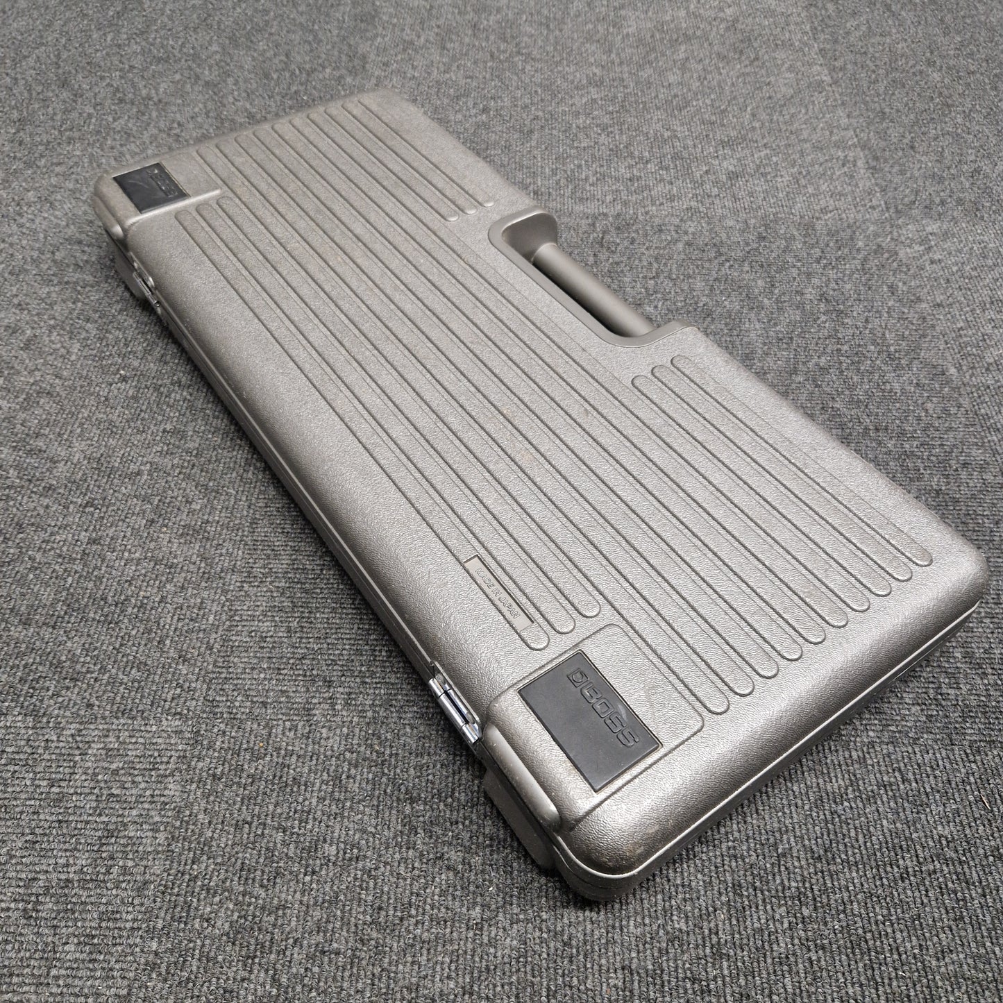 Pre-Owned Boss BCB-6 Silver metallic case on a textured gray surface