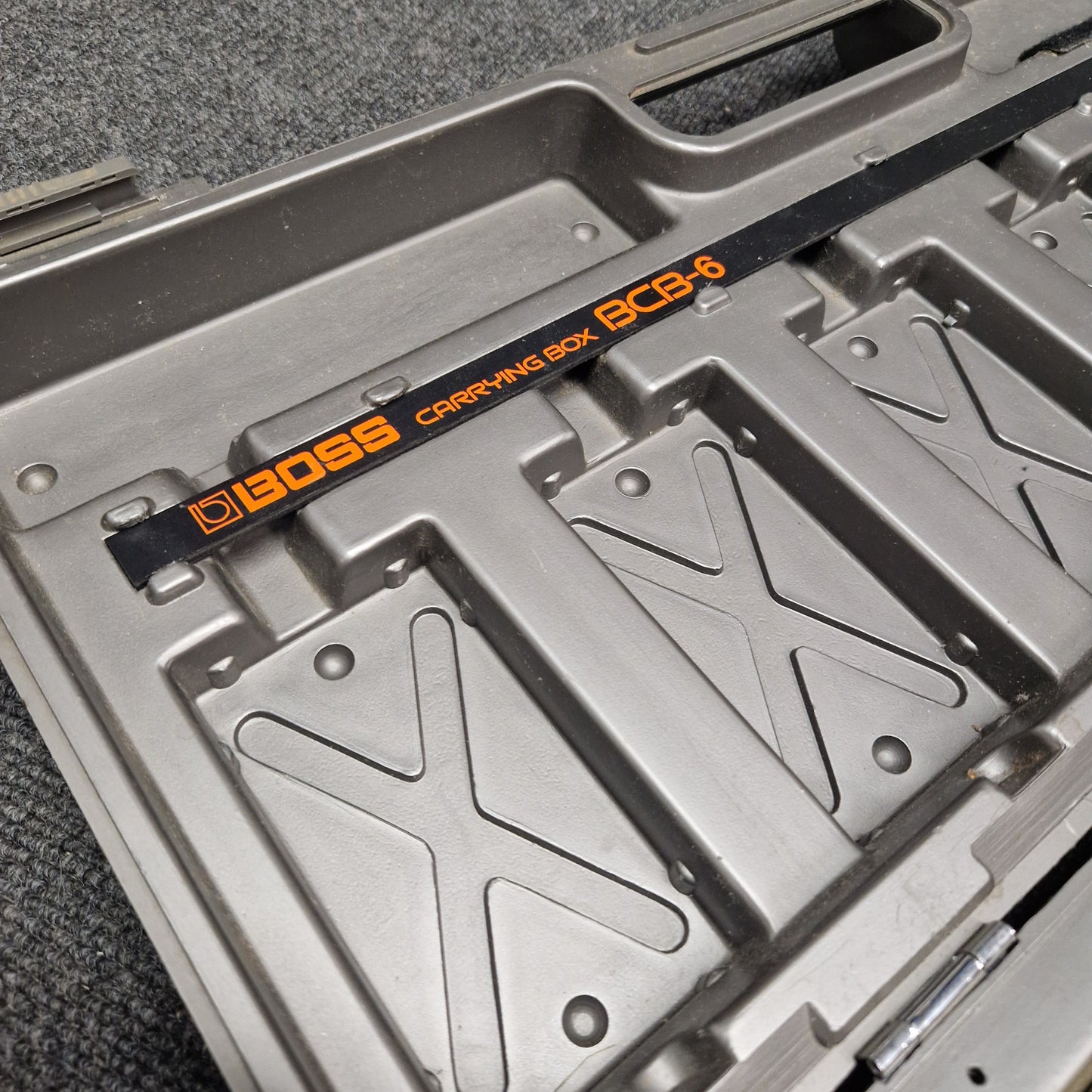 Pre-Owned Boss BCB-6 Metallic tray with a black strap displaying '9500' in orange text on a gray surface.