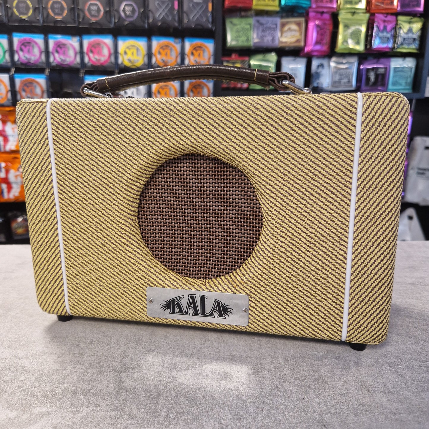 Pre-Owned Kala AMP-TWD Textured brown pouch with circular design and 'Kala' branding on a gray surface.