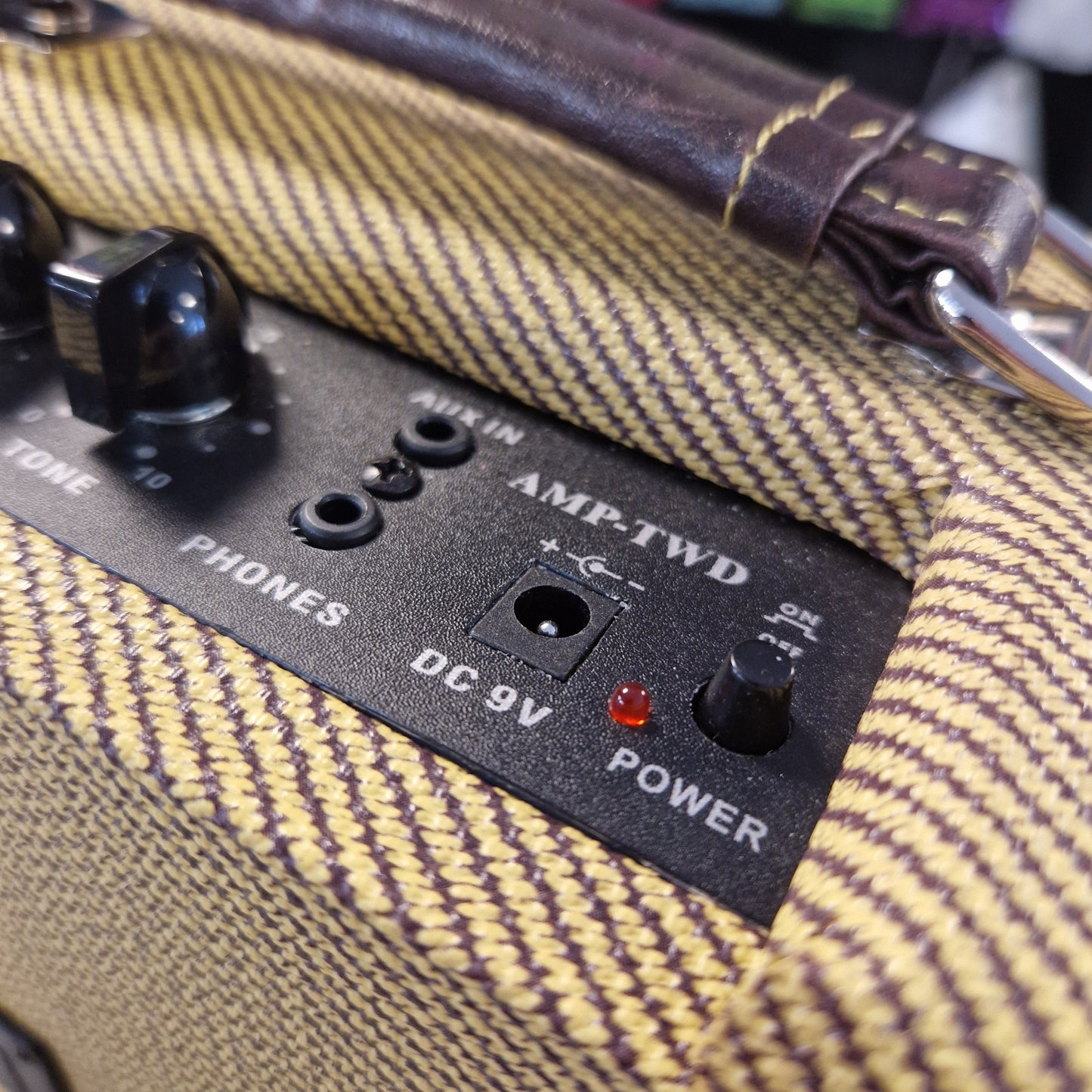 Pre-Owned Kala AMP-TWD Close-up of an amplifier with control panel and power indicator on a textured surface.