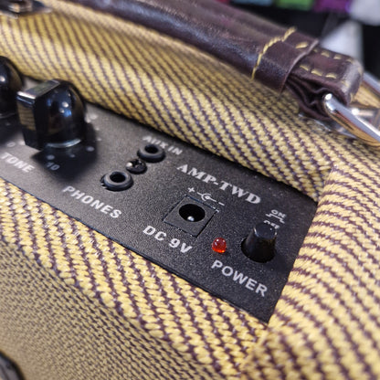 Pre-Owned Kala AMP-TWD Close-up of an amplifier with control panel and power indicator on a textured surface.