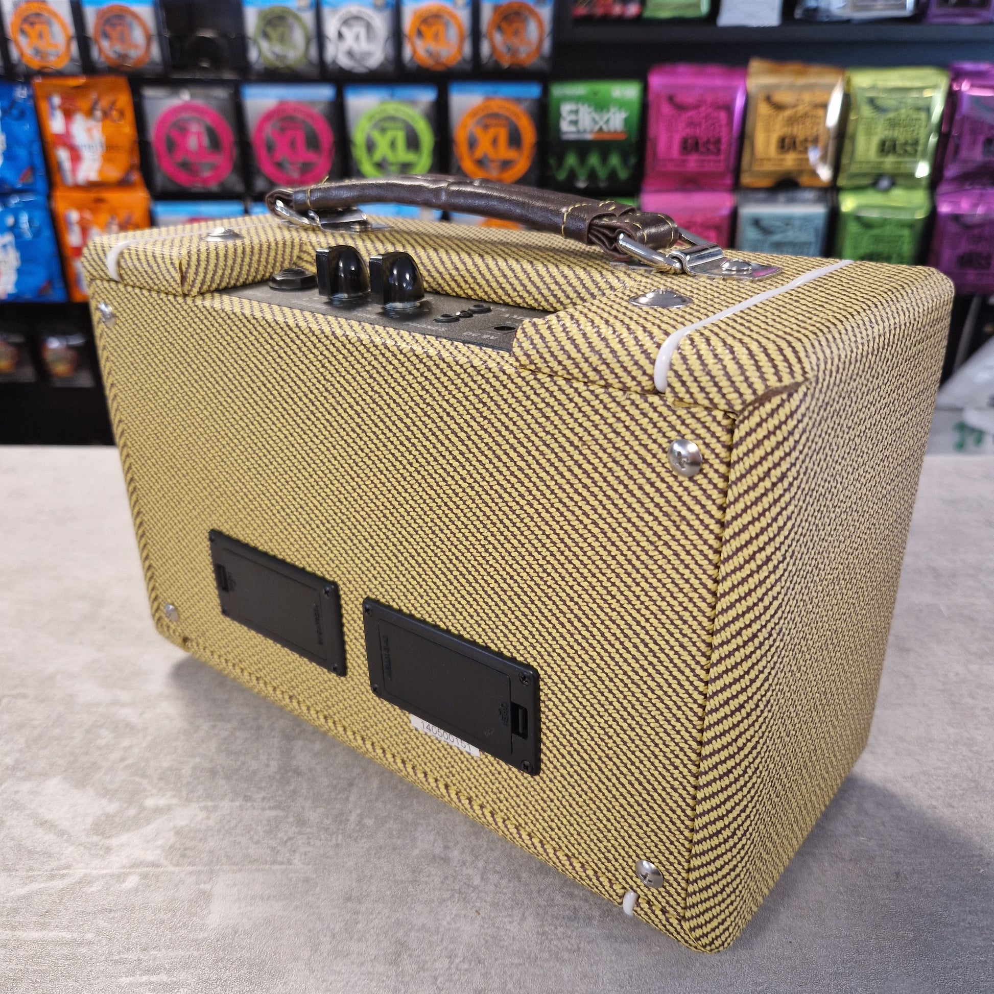 Pre-Owned Kala AMP-TWD Beige guitar amplifier on a gray surface with colorful boxes in the background