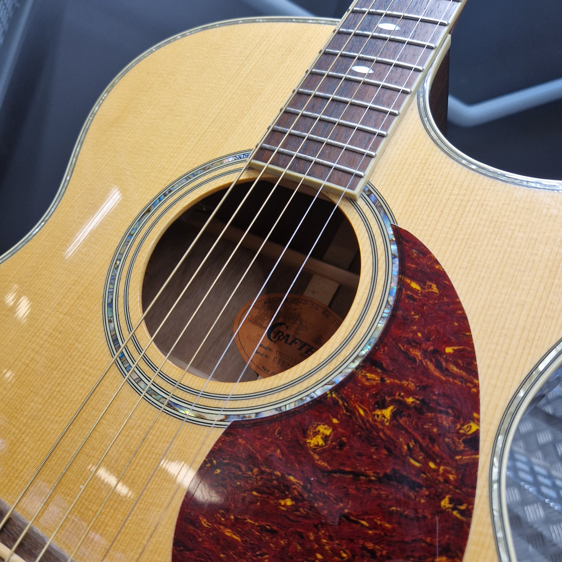 Pre-Owned Crafter TMC035/N Close-up of an acoustic guitar with a focus on the soundhole and neck.