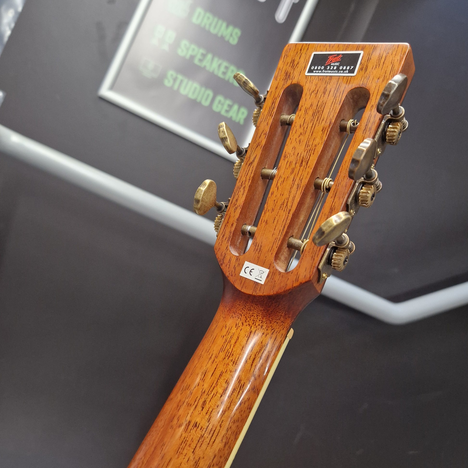 Pre-Owned Crafter TMC035/N Close-up of a guitar headstock with tuning pegs on a dark background