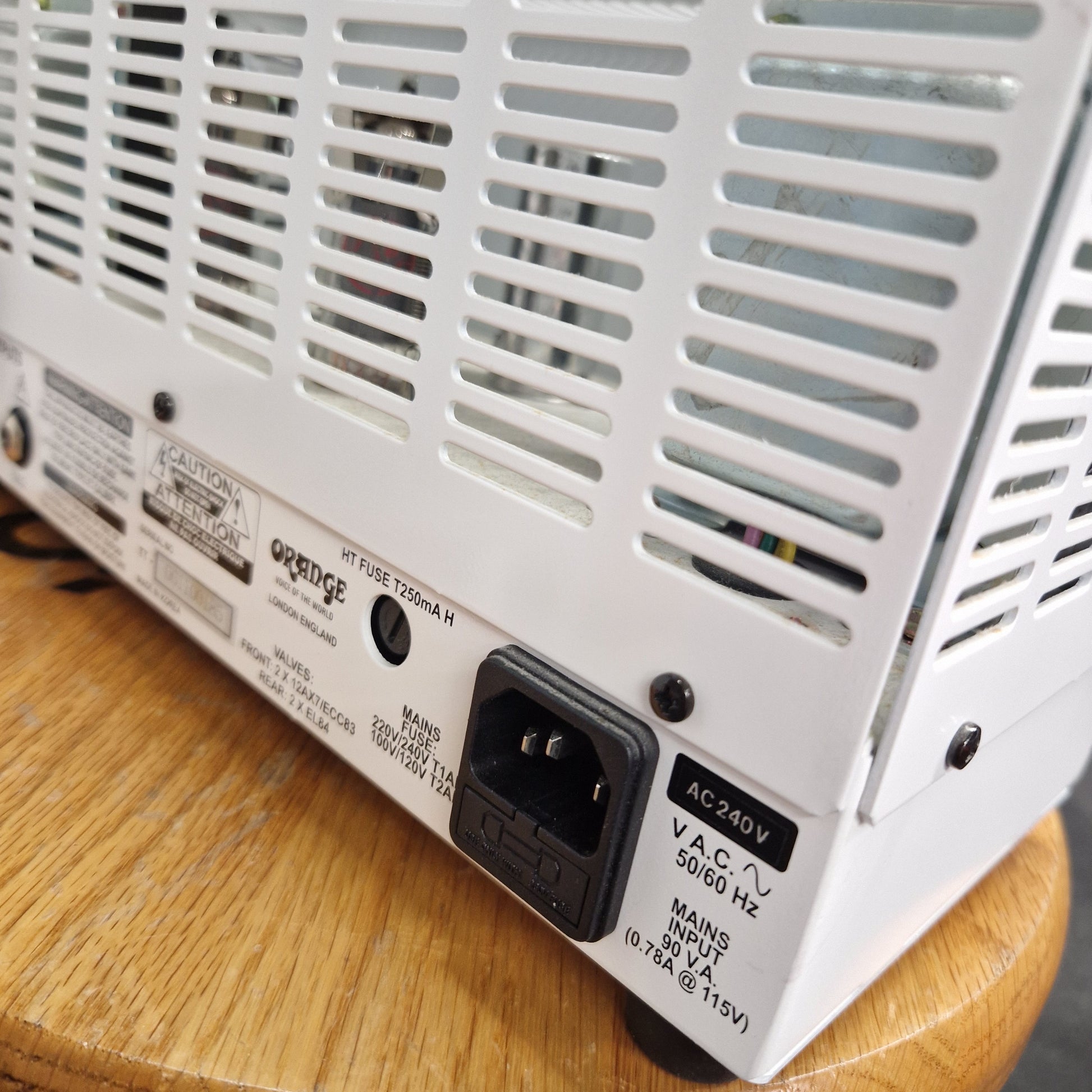 Pre-Owned Orange TT15H Back of a white electronic device with power connector on a wooden surface