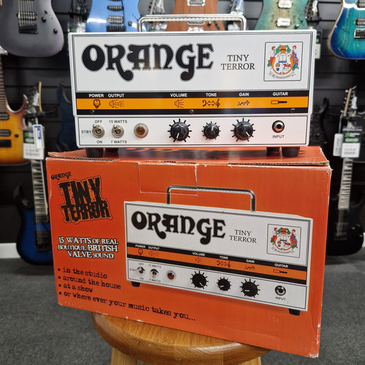 Pre-Owned Orange TT15H Orange Tiny Terror guitar effects pedal packaging on a guitar case background