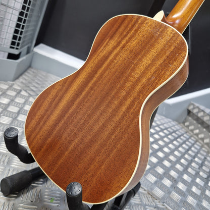 Pre-Owned Cordoba 15CM Close-up of a wooden acoustic guitar on a stand with a blurred background