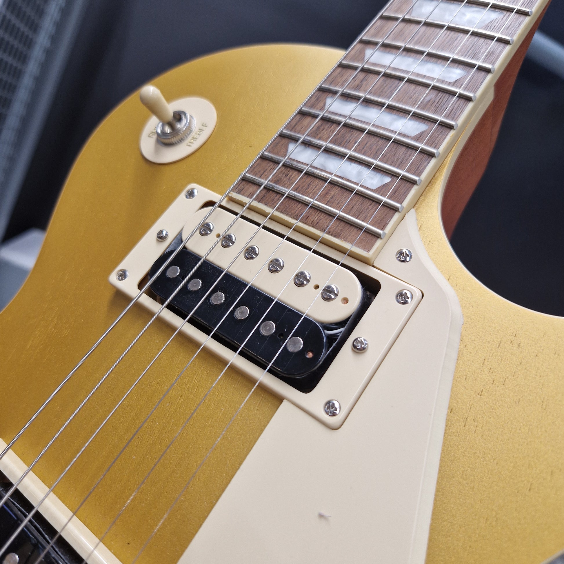 Pre-Owned Epiphone Les Paul Close-up of a guitar neck and bridge with a blurred background