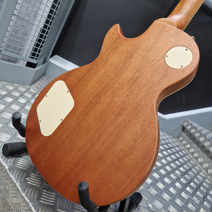 Pre-Owned Epiphone Les Paul Wooden electric guitar body on a stand with a metallic floor background