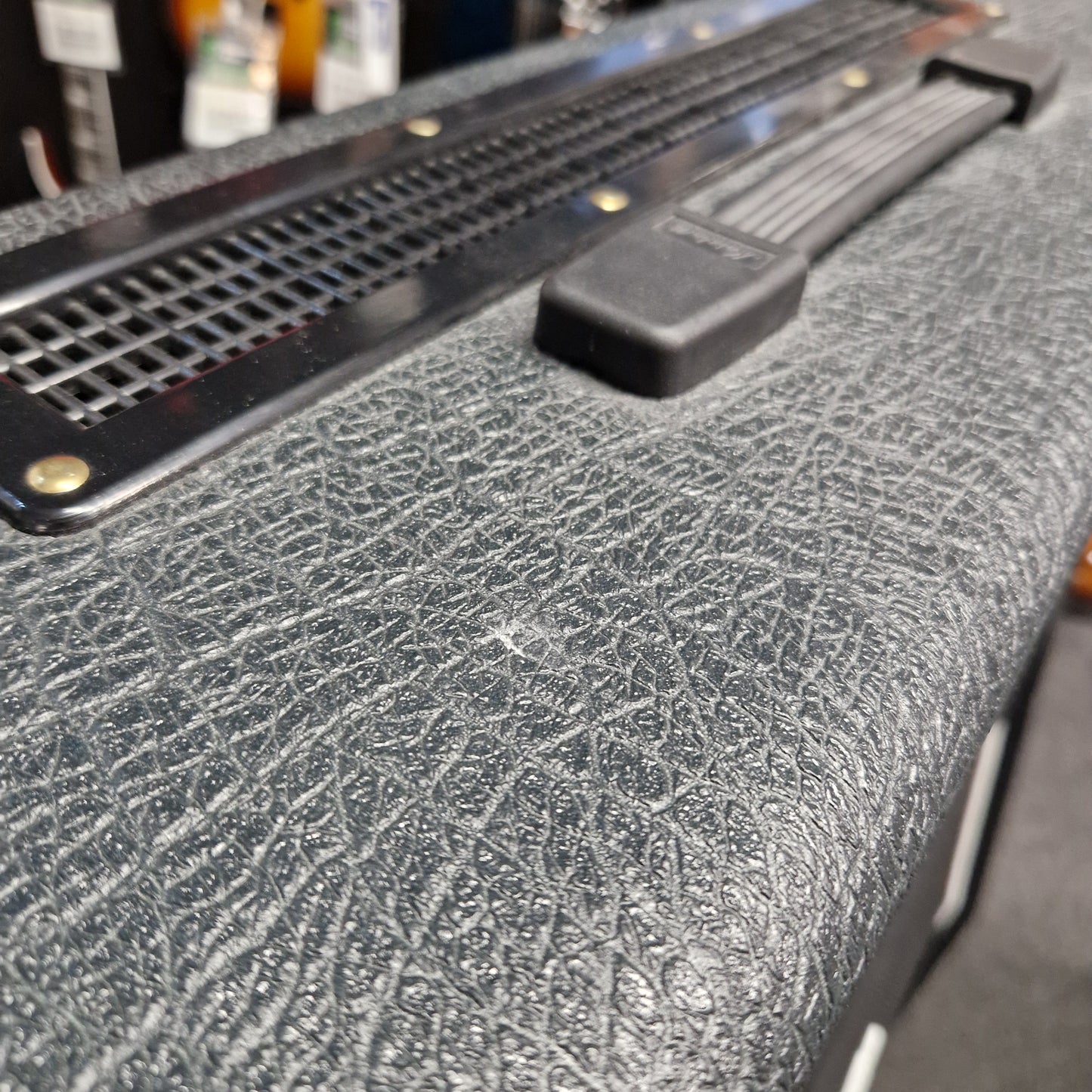 Pre-Owned Marshall JVM410H Close-up of a textured black surface with a metal bracket