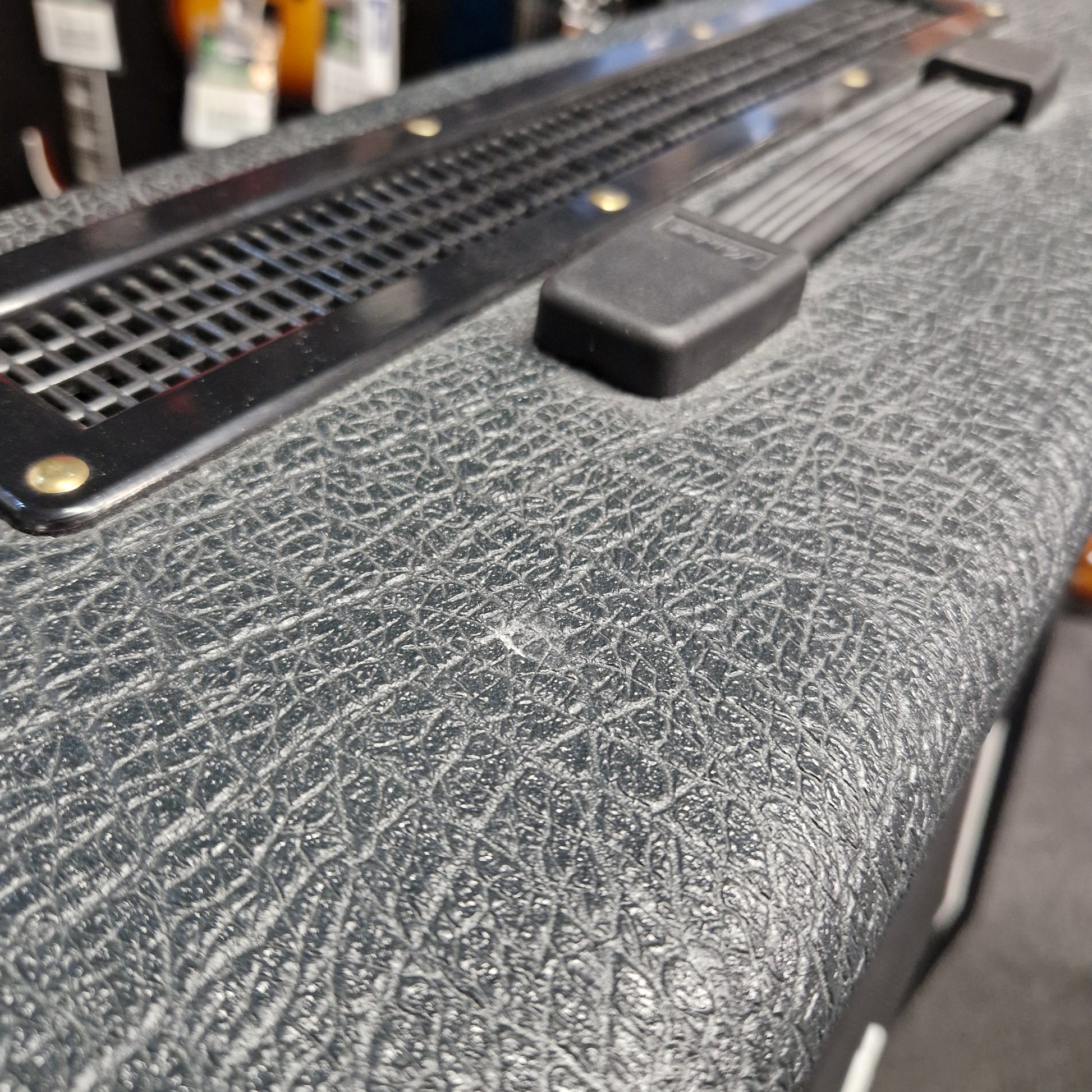 Pre-Owned Marshall JVM410H Close-up of a textured black surface with a metal bracket