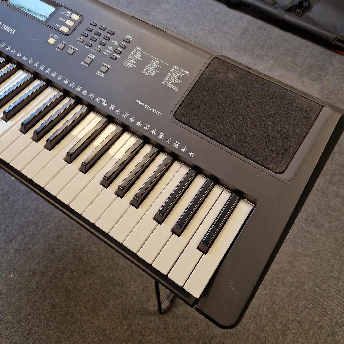 Pre-Owned Yamaha PSR-EW310 Keyboard on a gray surface