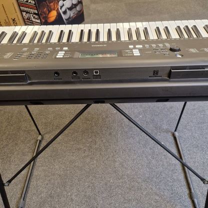 Pre-Owned Yamaha PSR-EW310 Close-up of a keyboard with a textured wall in the background