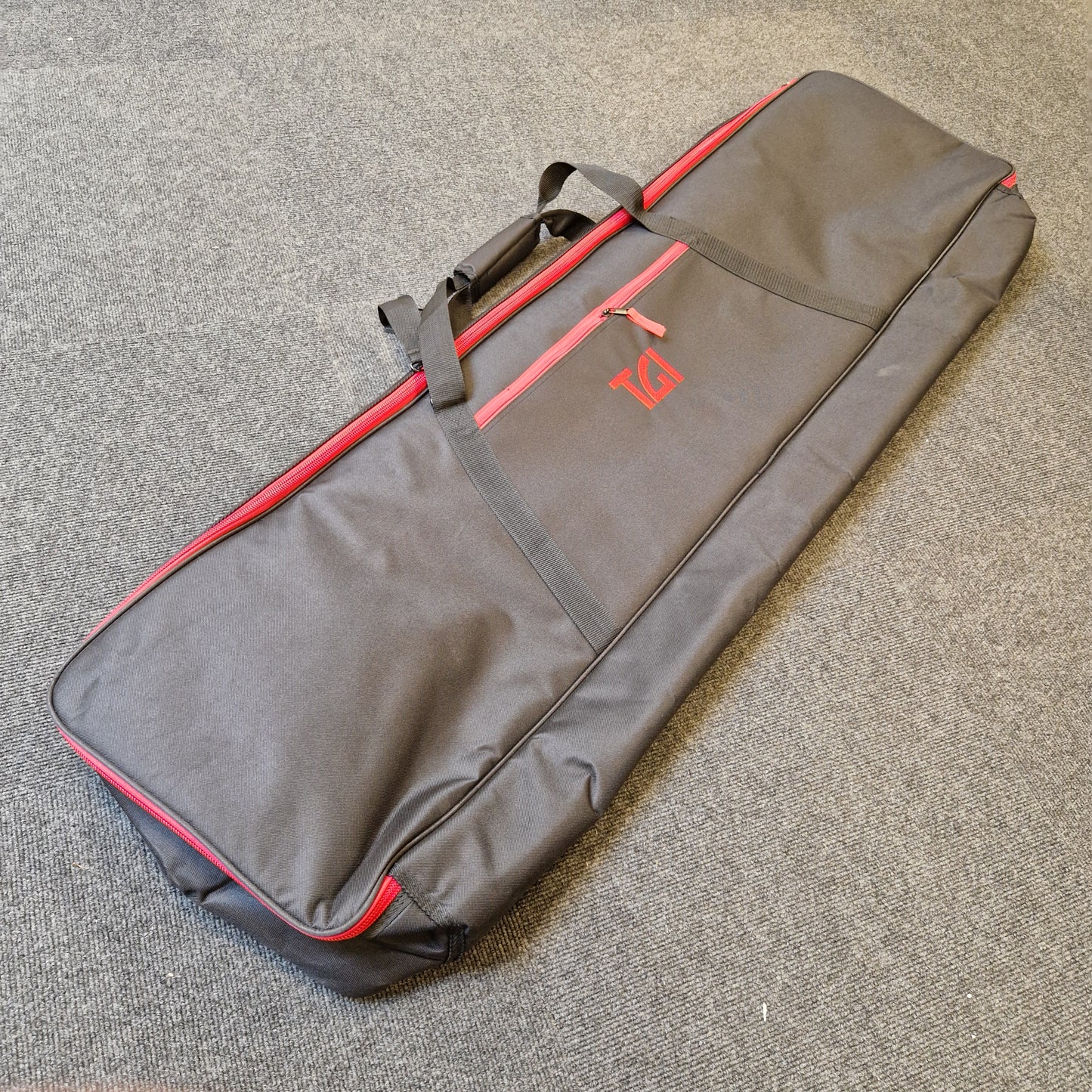 Pre-Owned Yamaha PSR-EW310 Gray and red guitar case on a textured surface