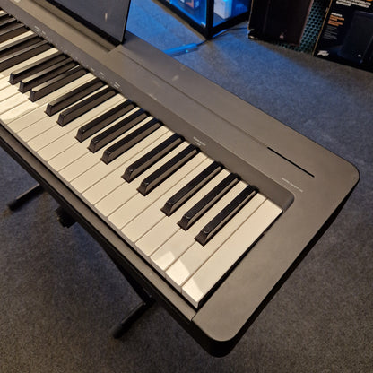 Pre-Owned Yamaha P-145B Digital piano on a gray surface with a blurred background