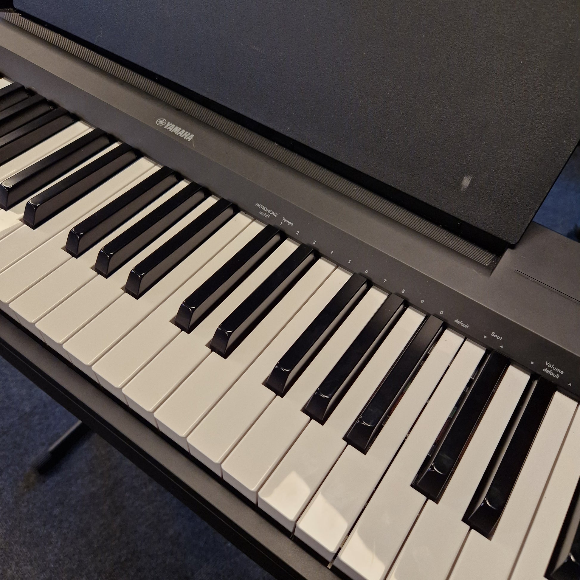 Pre-Owned Yamaha P-145B Digital piano keyboard with Yamaha logo on a dark background