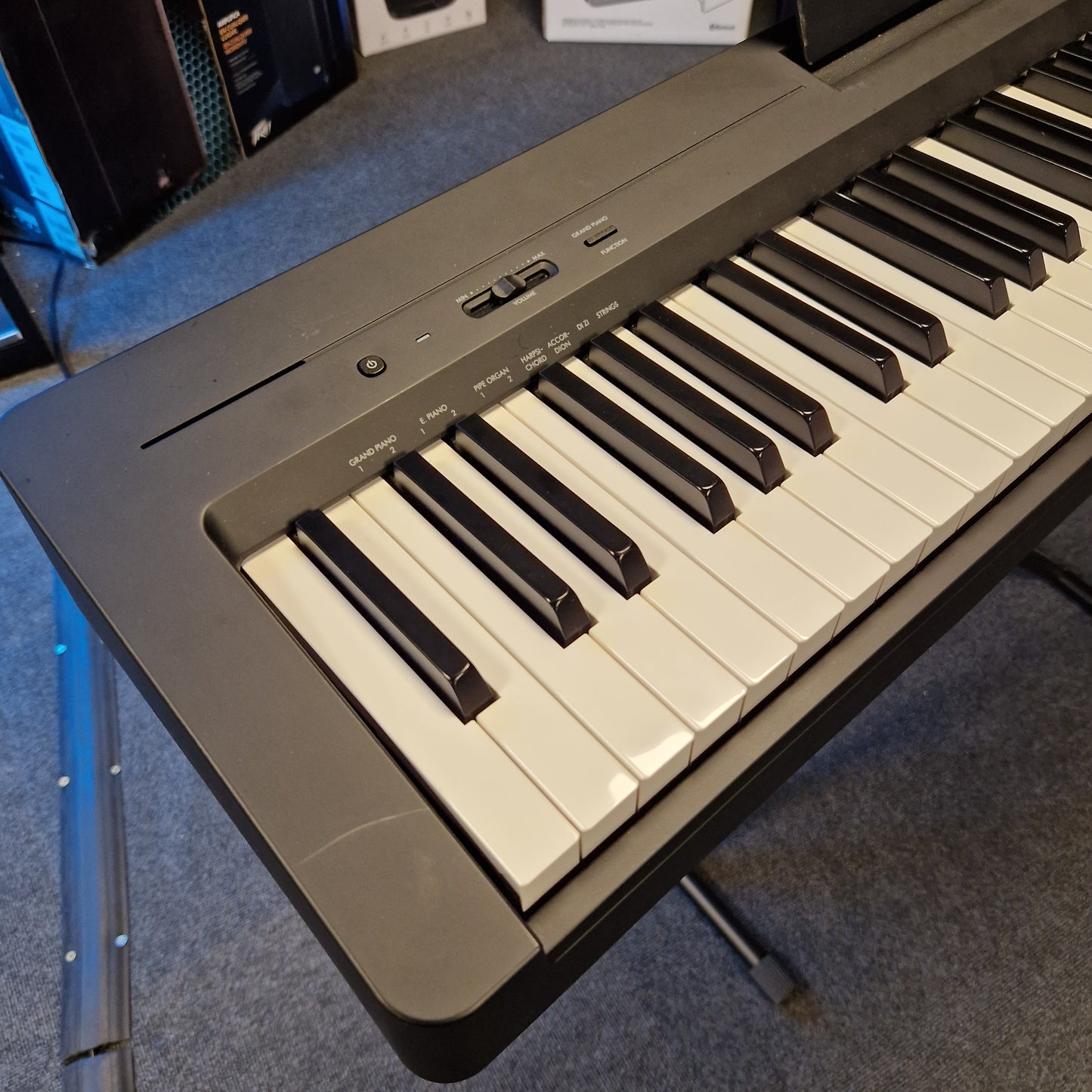 Pre-Owned Yamaha P-145B Keyboard on a gray surface with a blurred background