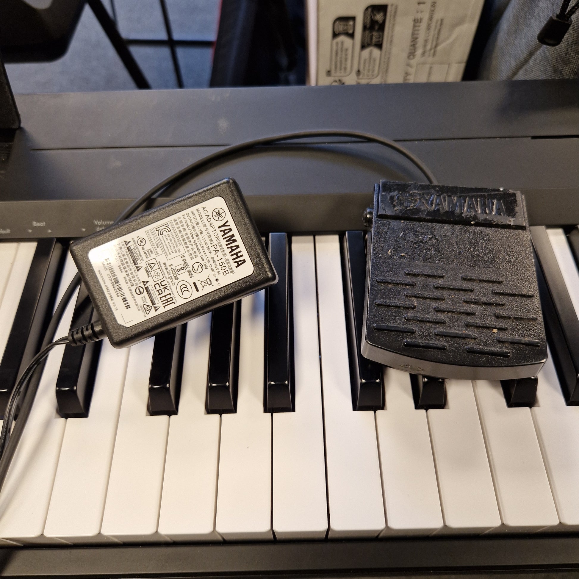 Pre-Owned Yamaha P-145B Yamaha power adapter attached to a keyboard with visible branding.