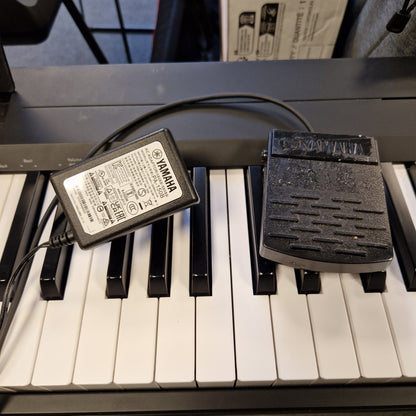 Pre-Owned Yamaha P-145B Yamaha power adapter attached to a keyboard with visible branding.