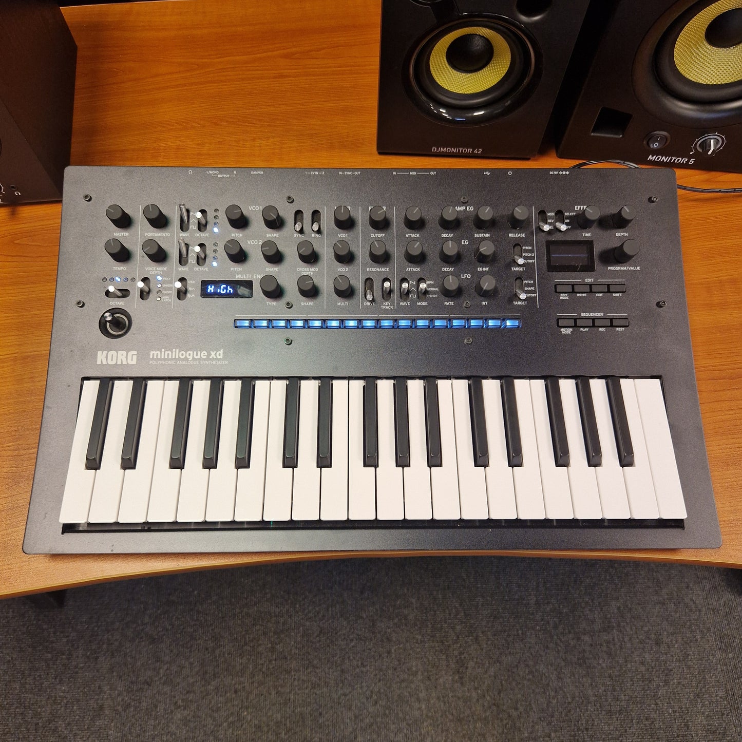 Pre-Owned Korg Minilogue XD Keyboard controller with knobs and buttons on a wooden surface