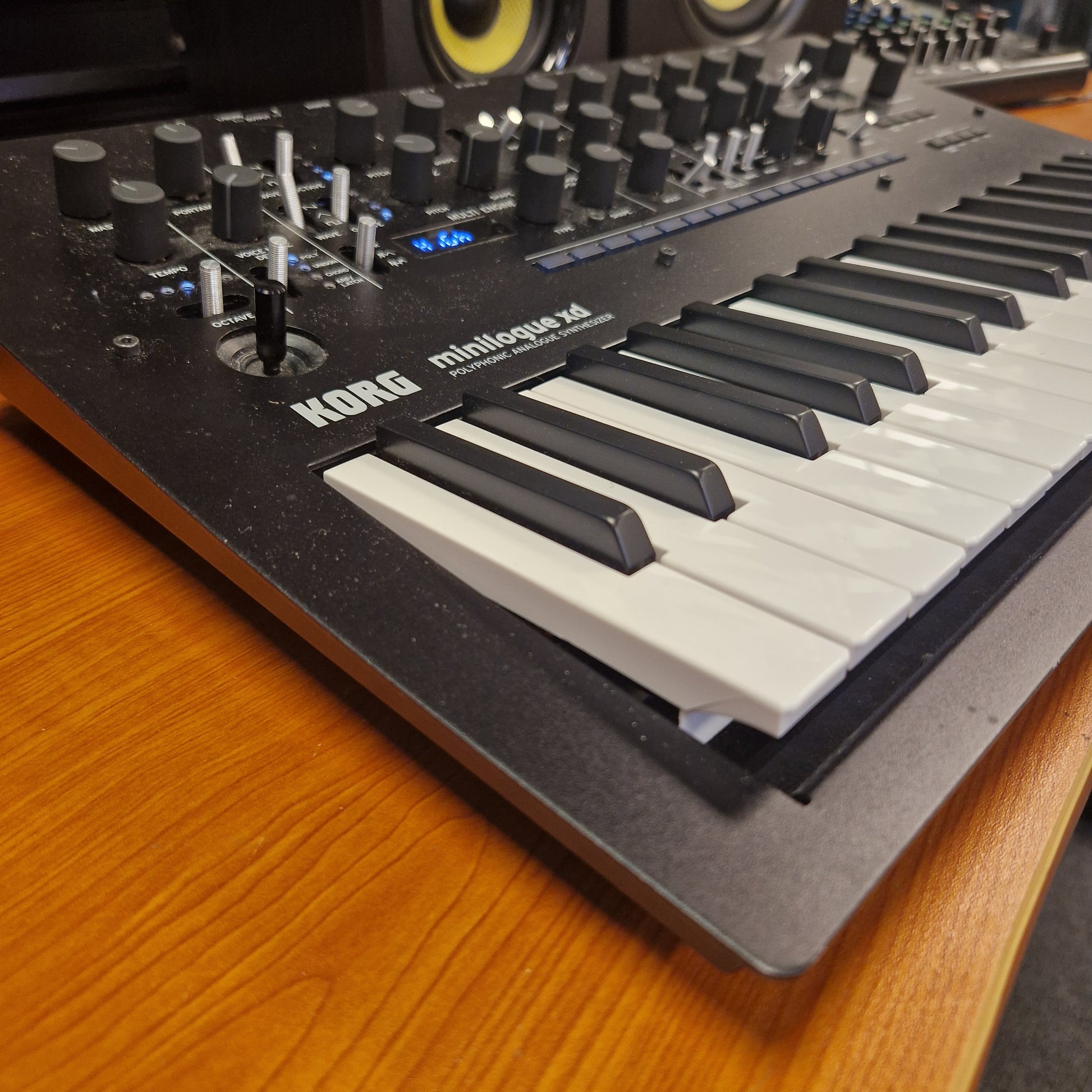 Pre-Owned Korg Minilogue XD Keyboard controller with knobs and buttons on a wooden surface
