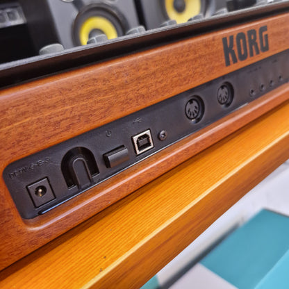Pre-Owned Korg Minilogue XD Close-up of a KORG electronic device with wooden finish and control panel.