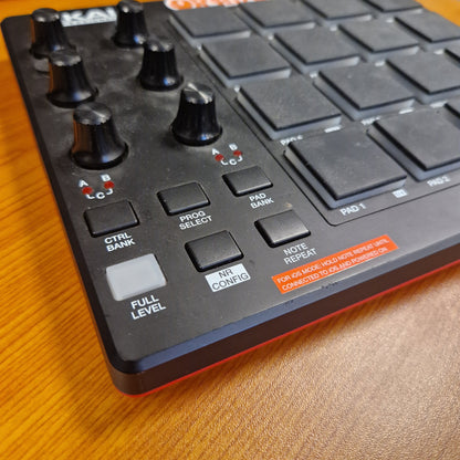 Pre-Owned Akai MPD218 Control panel with buttons and knobs on a wooden surface
