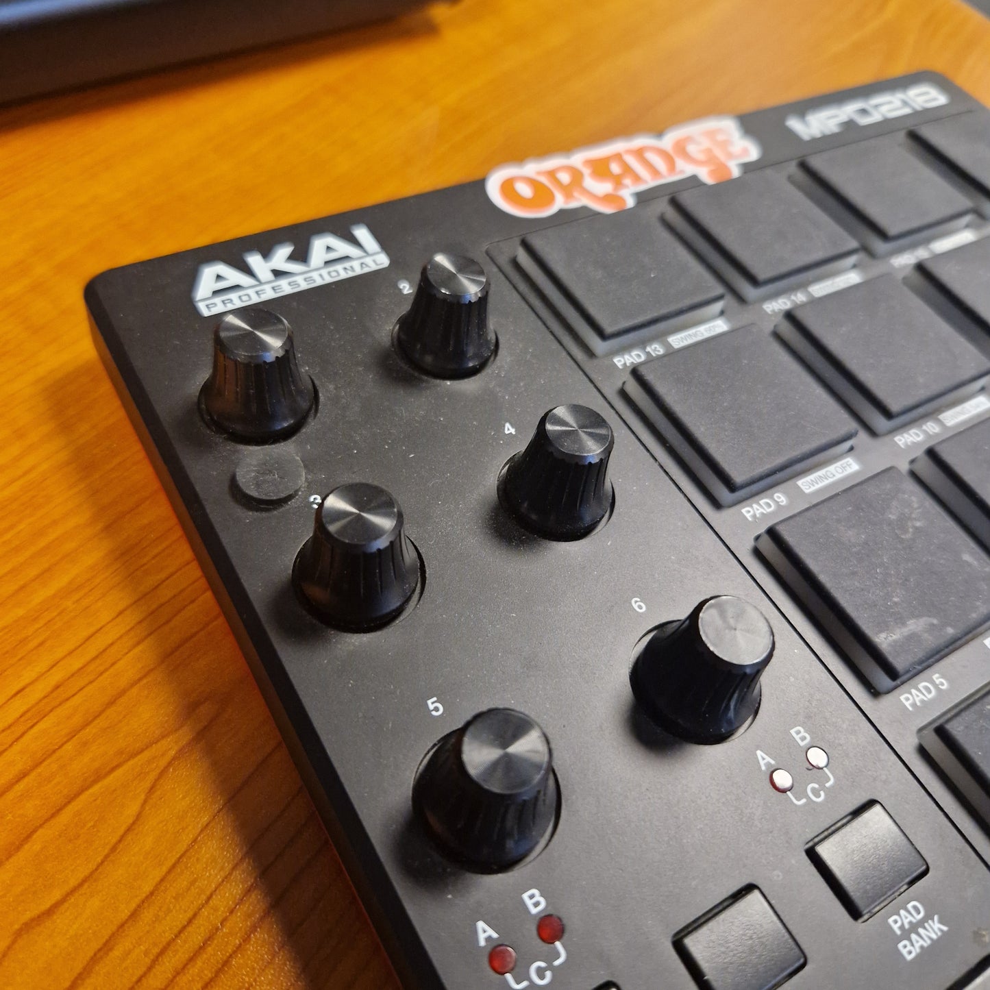 Pre-Owned Akai MPD218 Close-up of a Roland Akai electronic music controller on a wooden surface