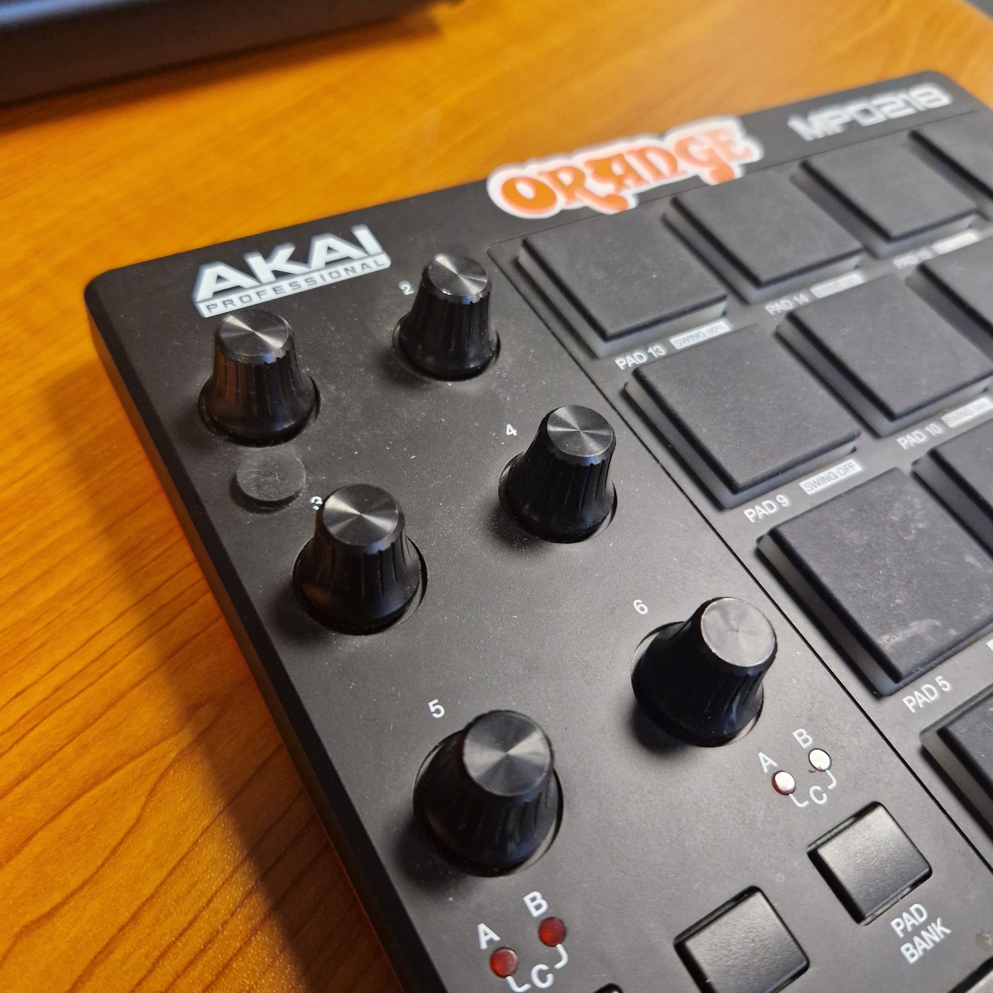 Pre-Owned Akai MPD218 Close-up of a Roland Akai electronic music controller on a wooden surface