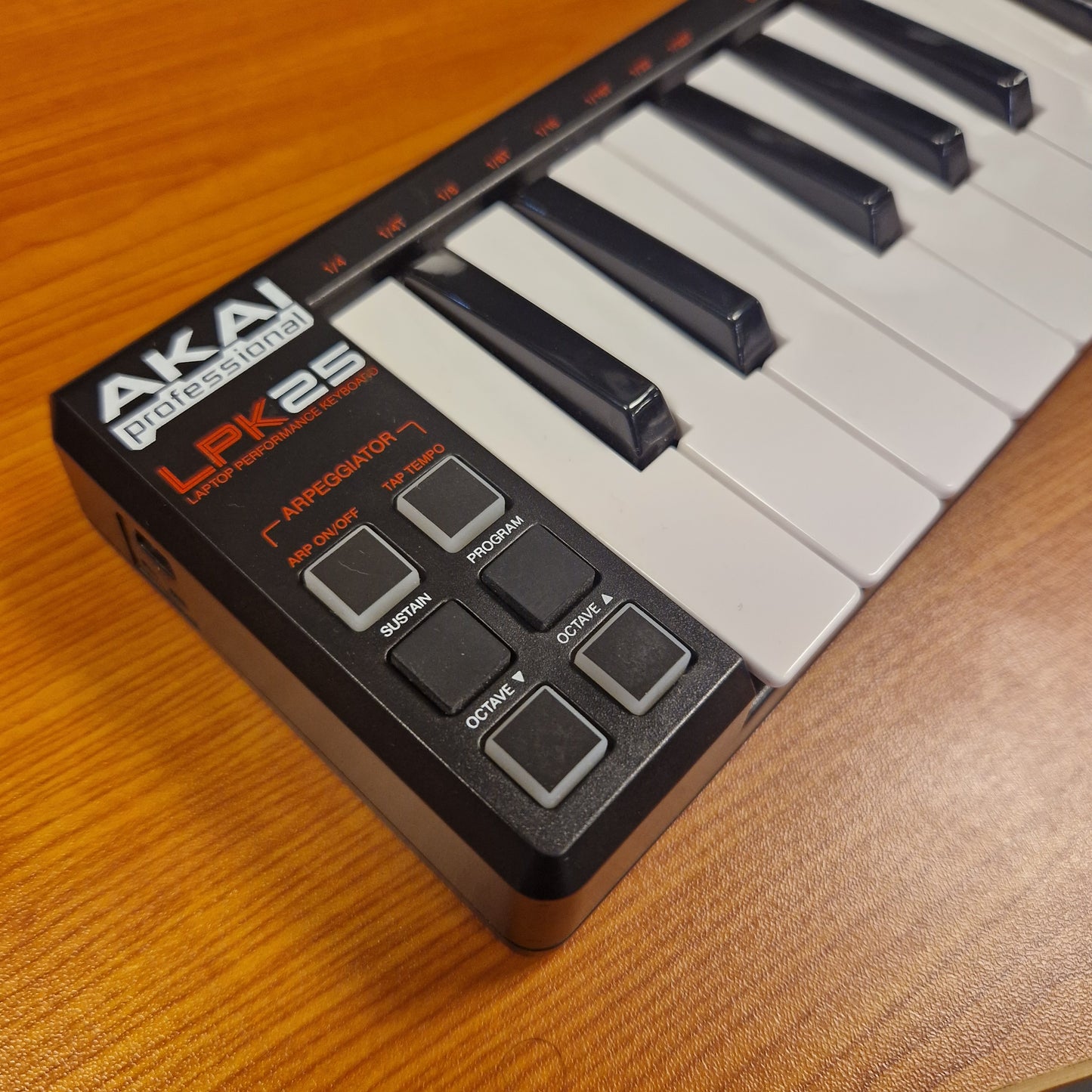 Pre-Owned Akai LPK25 Keyboard controller on a wooden surface