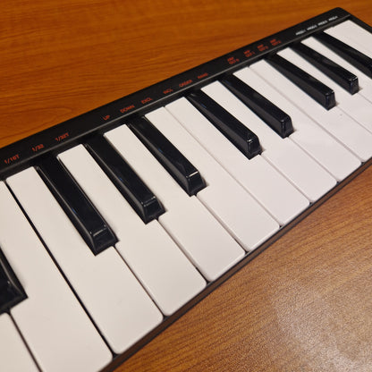 Pre-Owned Akai LPK25 Close-up of a keyboard with black and white keys on a wooden surface