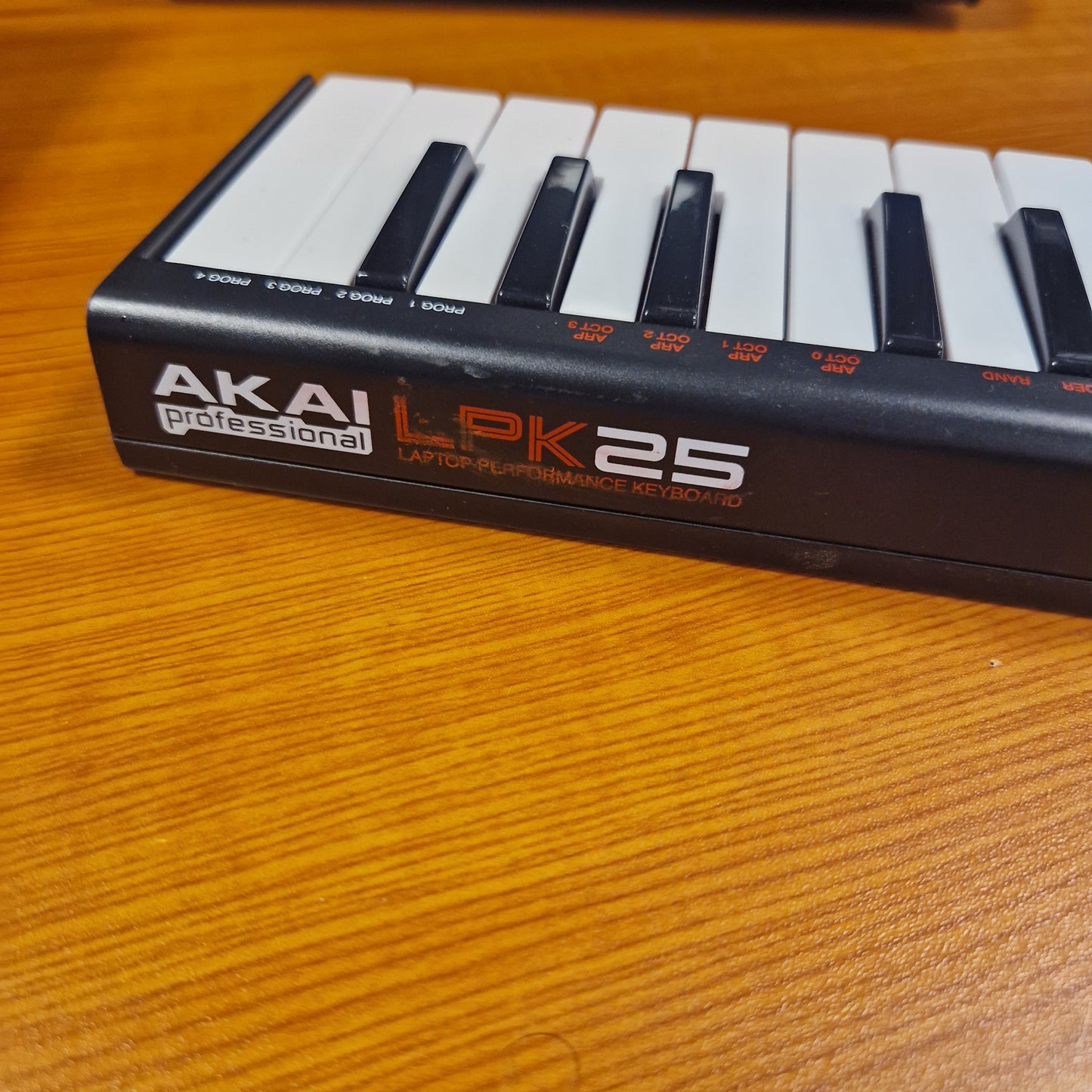 Pre-Owned Akai LPK25 Akai LPK25 MIDI keyboard on a wooden surface