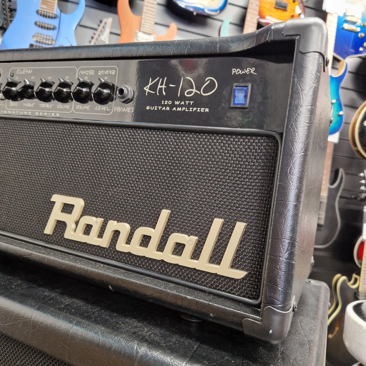 Pre-Owned Randall KH-120 Guitar amplifier with 'Randall' branding on a background of other musical instruments.