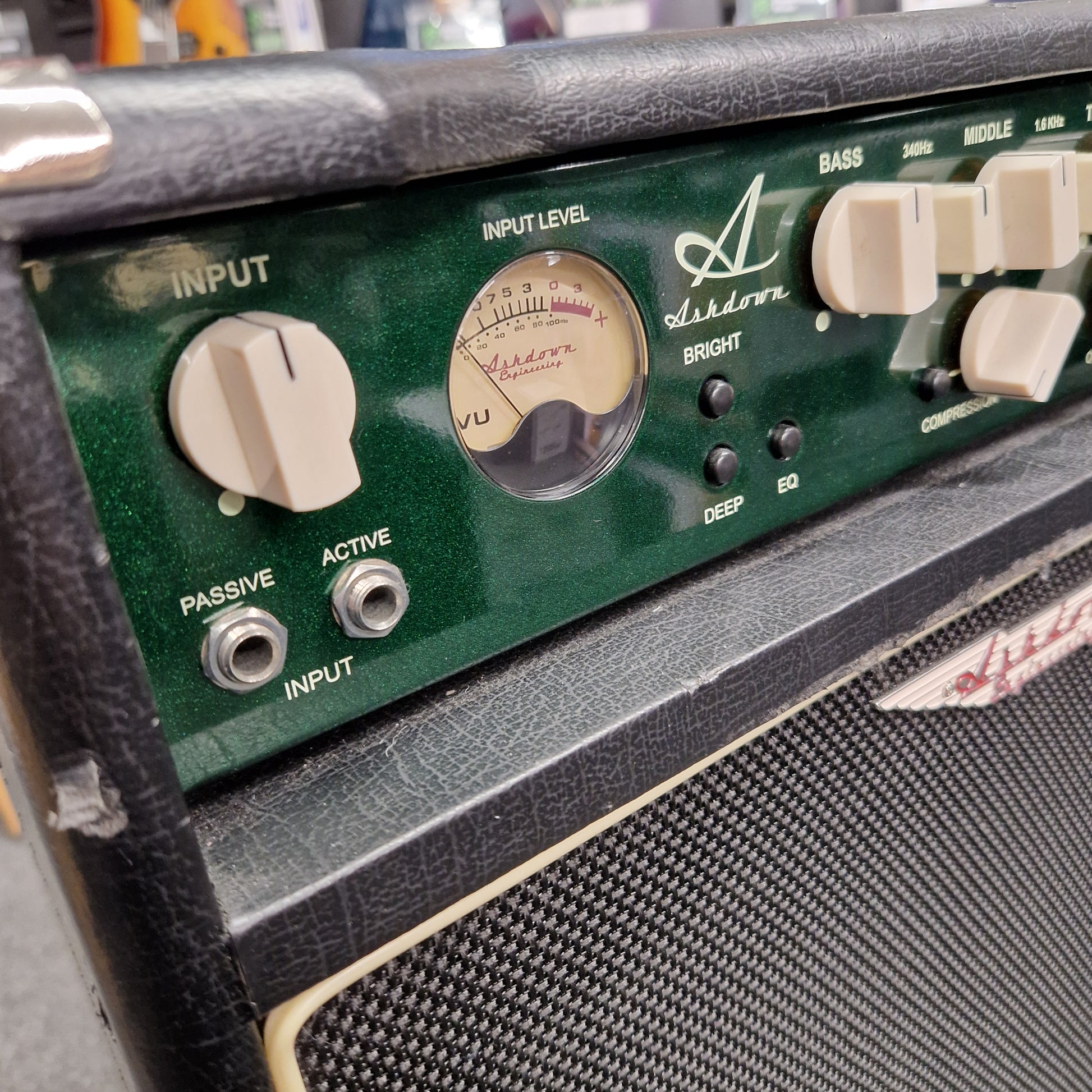 Pre-Owned Ashdown MAG-C210T-300EVO Close-up of a guitar amplifier control panel with various knobs and labels.