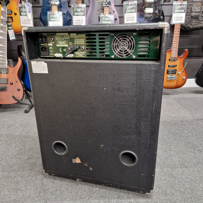 Pre-Owned Ashdown MAG-C210T-300EVO Black speaker cabinet with visible internal components on a gray surface with guitars in the background
