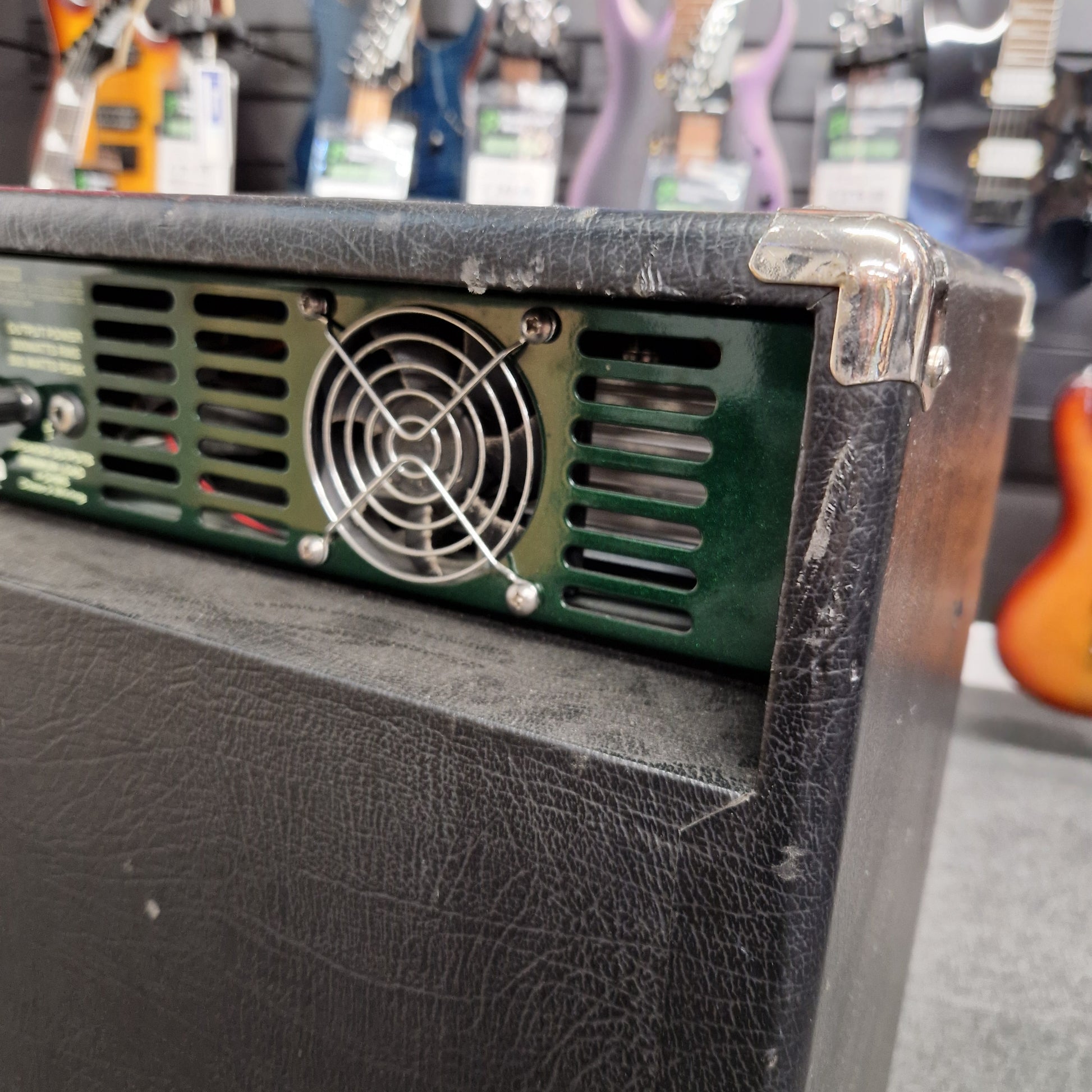 Pre-Owned Ashdown MAG-C210T-300EVO Close-up of a guitar amplifier with a fan visible inside, blurred background