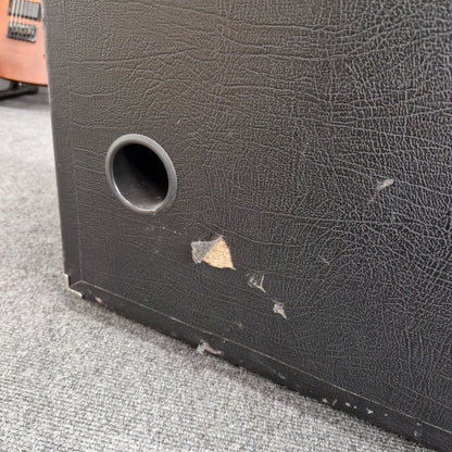 Pre-Owned Ashdown MAG-C210T-300EVO Close-up of a textured black surface with a circular hole, possibly a speaker or electronic component.