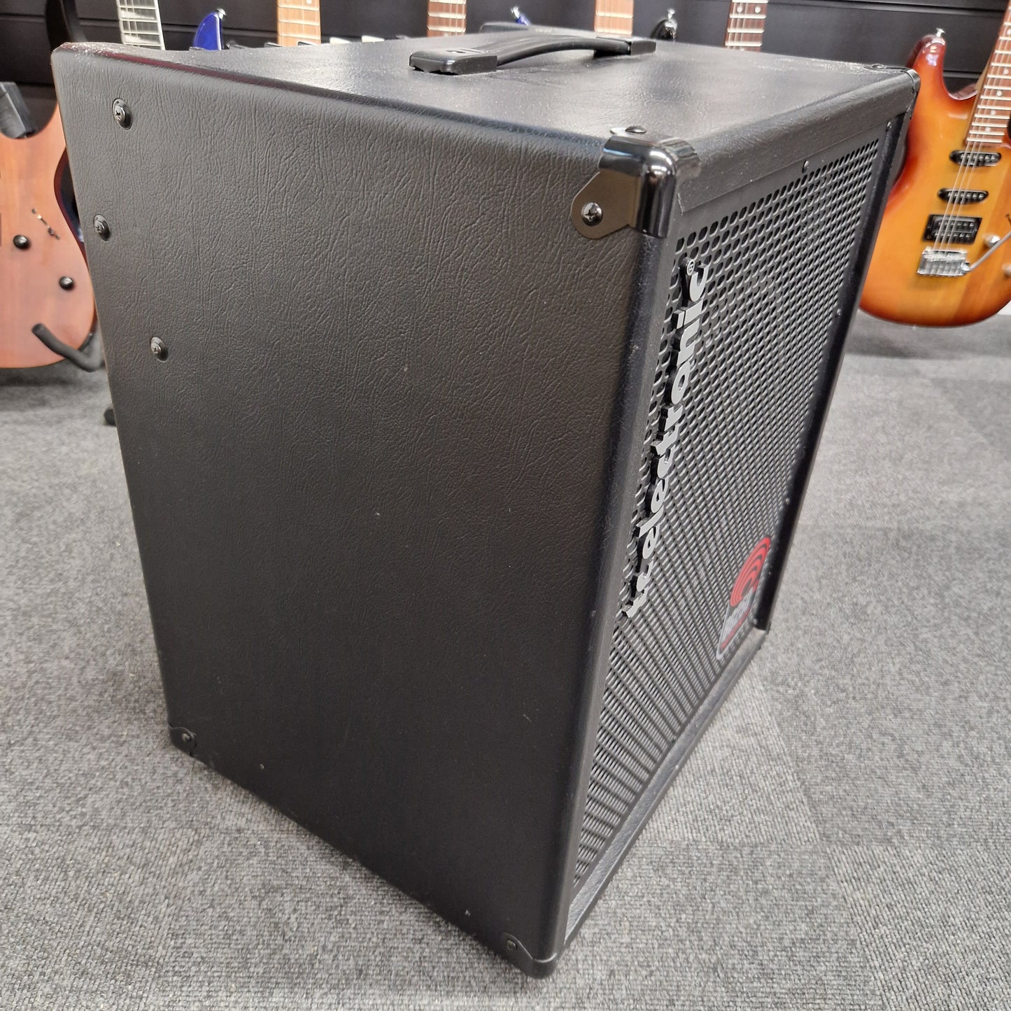Pre-Owned TC Electronic BG250-112 Guitar amplifier on a gray surface with guitars in the background
