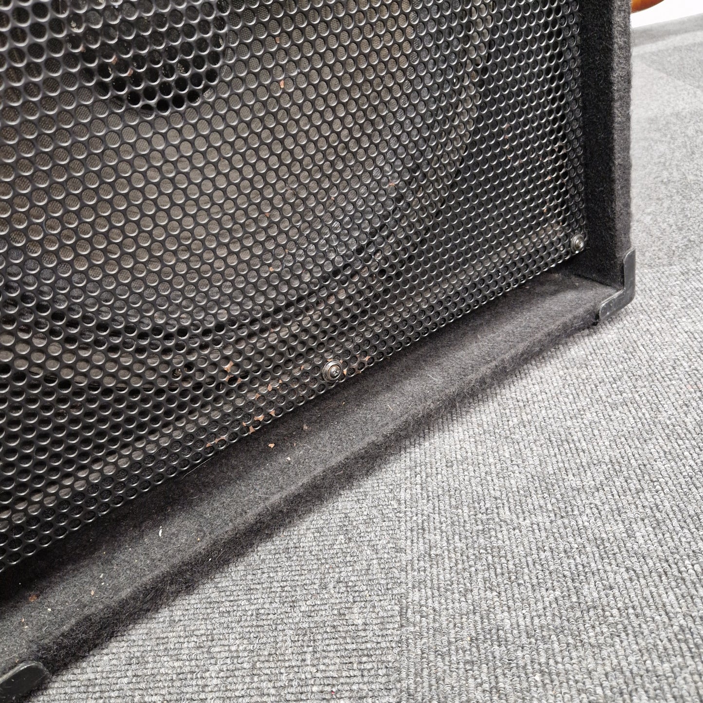 Pre-Owned Fender Rumble 100 Black speaker grill on a textured gray surface