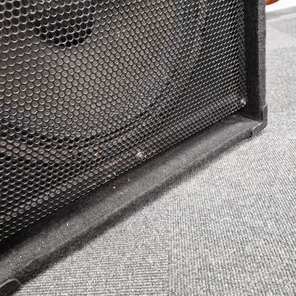 Pre-Owned Fender Rumble 100 Black speaker grill on a textured gray surface