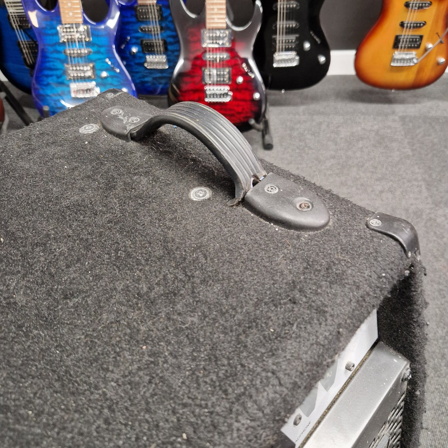 Pre-Owned Warwick BC300 Close-up of a guitar case with guitars in the background