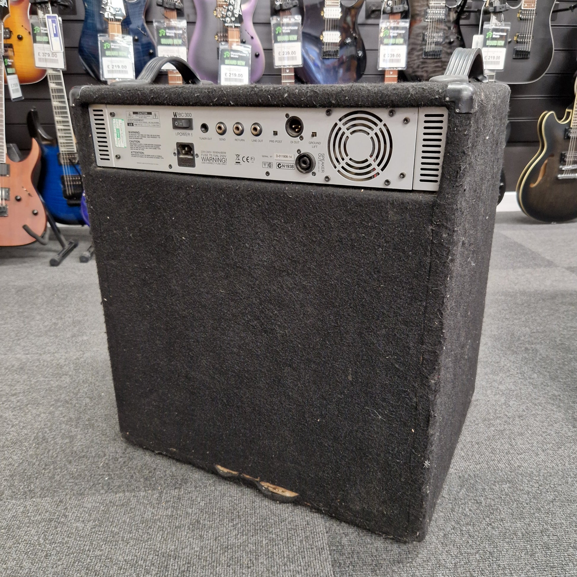 Pre-Owned Warwick BC300 Black guitar amplifier on a gray floor with guitars in the background