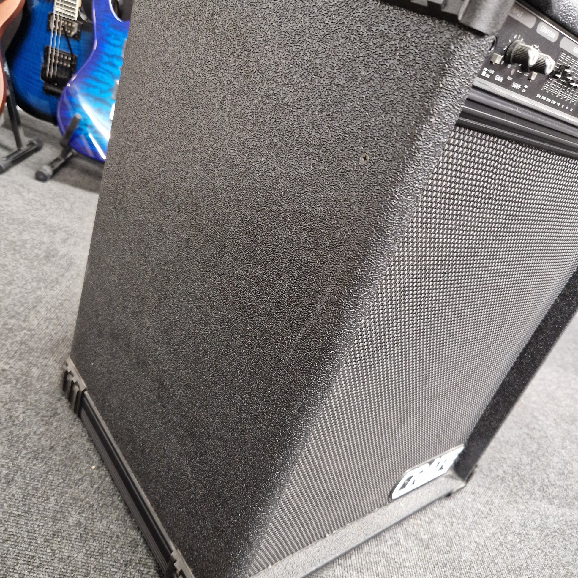Pre-Owned Crate BX-100 Guitar amplifier with a blue electric guitar on a gray surface