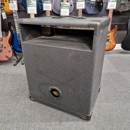 Pre-Owned Crate BX-100 Gray speaker cabinet on a gray floor with guitars in the background