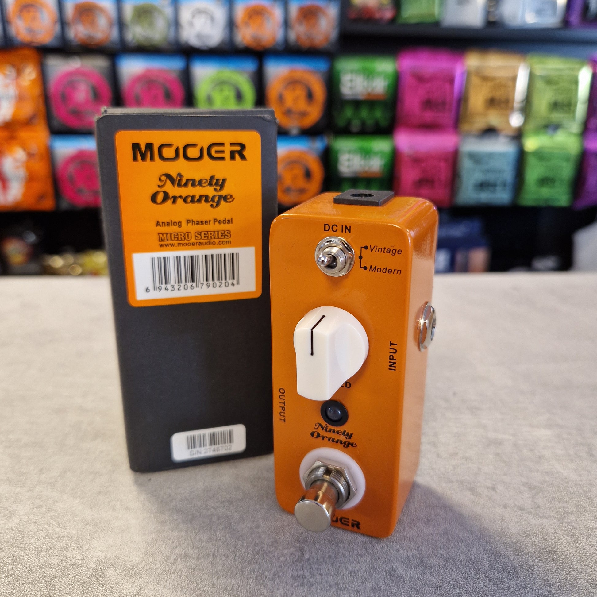 Pre-Owned Mooer MPH1 Orange guitar effects pedal with a visible brand label on a textured surface.