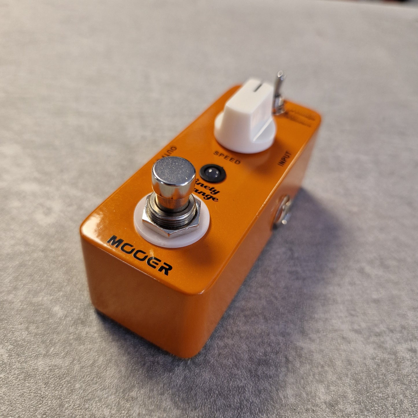 Pre-Owned Mooer MPH1 Orange guitar effects pedal with white knobs on a gray surface