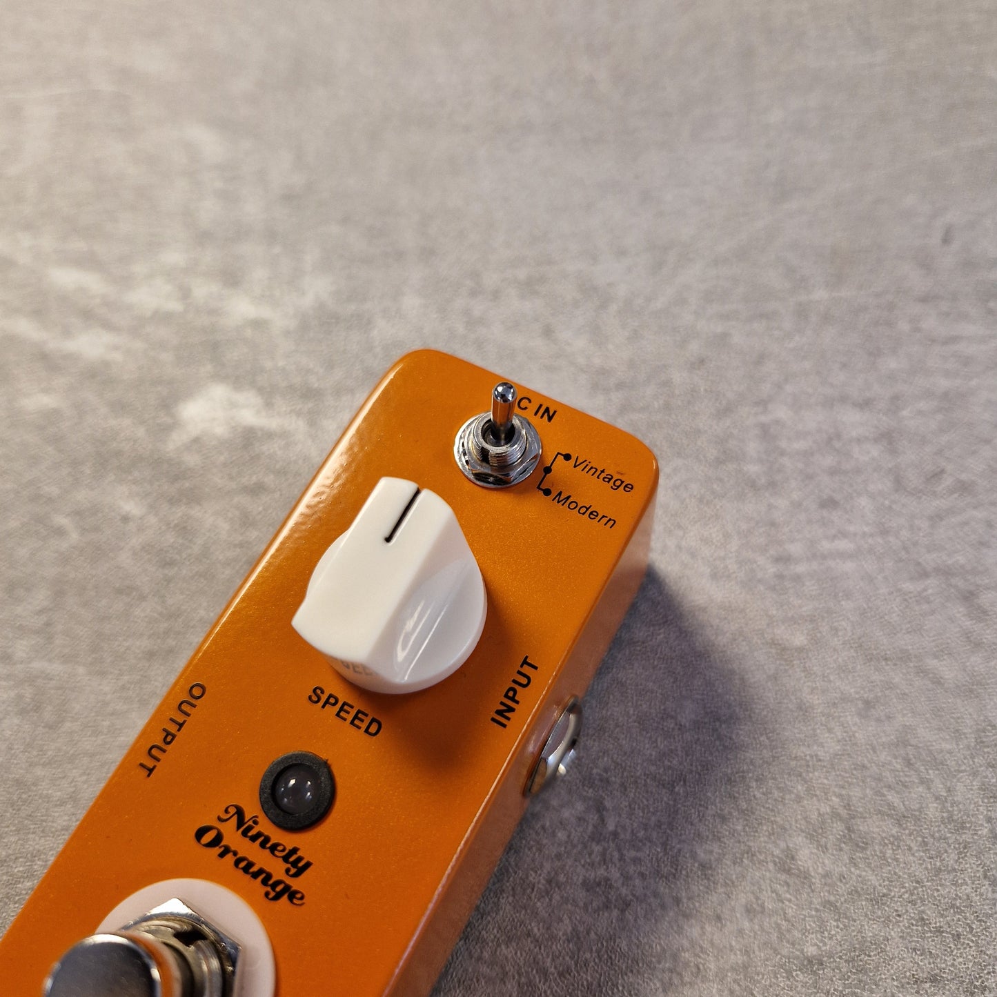 Pre-Owned Mooer MPH1 Orange guitar effects pedal with control knobs on a gray surface