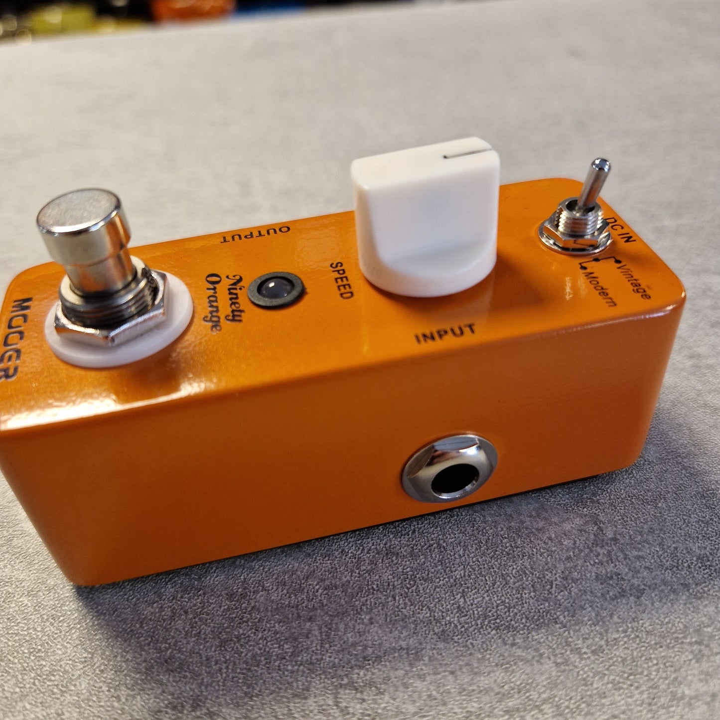 Pre-Owned Mooer MPH1 Orange guitar effects pedal with control knobs and labels on a textured surface