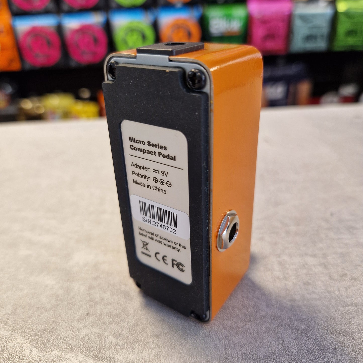 Pre-Owned Mooer MPH1 Orange and black electronic pedal with a label on a textured surface